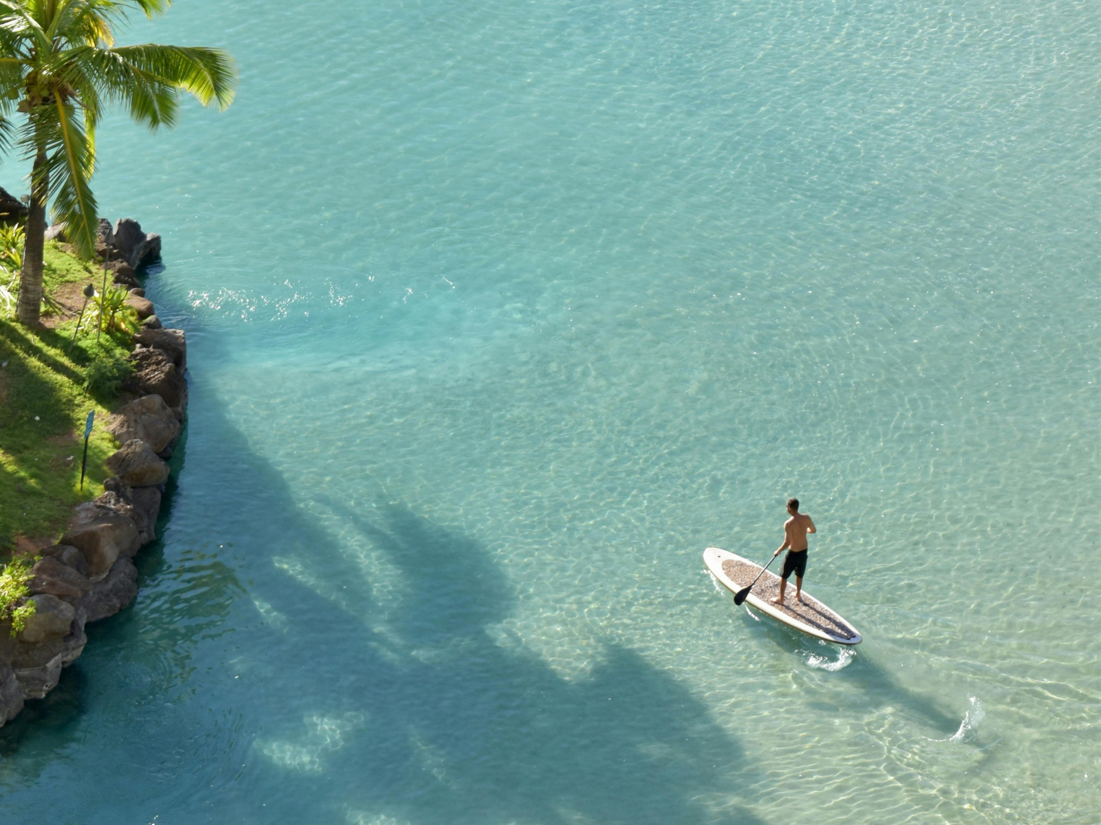 Portable rechargeable 12V SUP pump by LuxeFloat, lightweight and compact, inflating a paddleboard with a digital display and automatic shut-off, designed for up to 20 PSI